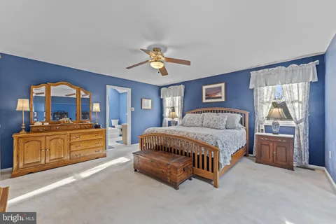 a spacious bedroom with a bed and a dresser