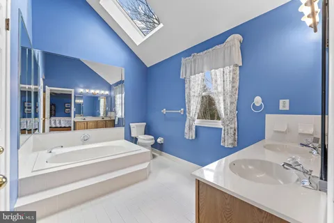 a spacious bathroom with a tub sink and mirror
