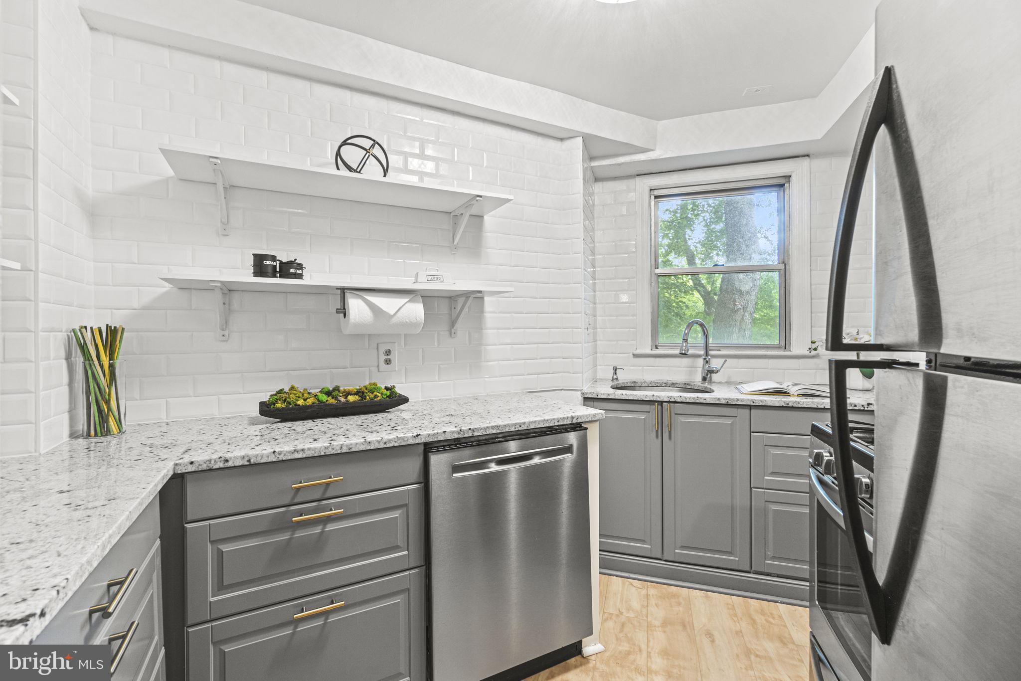 2500 Q Street Northwest, Unit 206 Washington, DC 20007 - Photo 9 of 21 a kitchen with stainless steel appliances granite countertop a sink a stove and a refrigerator