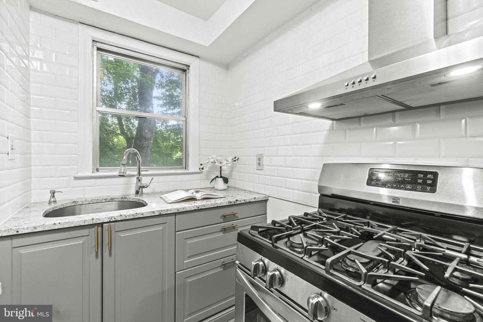 2500 Q Street Northwest, Unit 206 Washington, DC 20007 - Photo 10 of 21 a kitchen with a stove a sink and a window