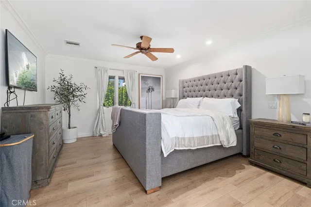 a spacious bedroom with a bed and a chandelier