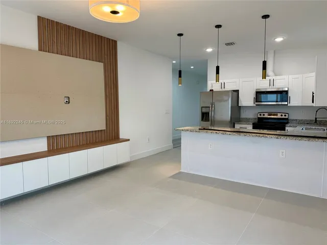 a kitchen with stainless steel appliances a refrigerator sink and microwave