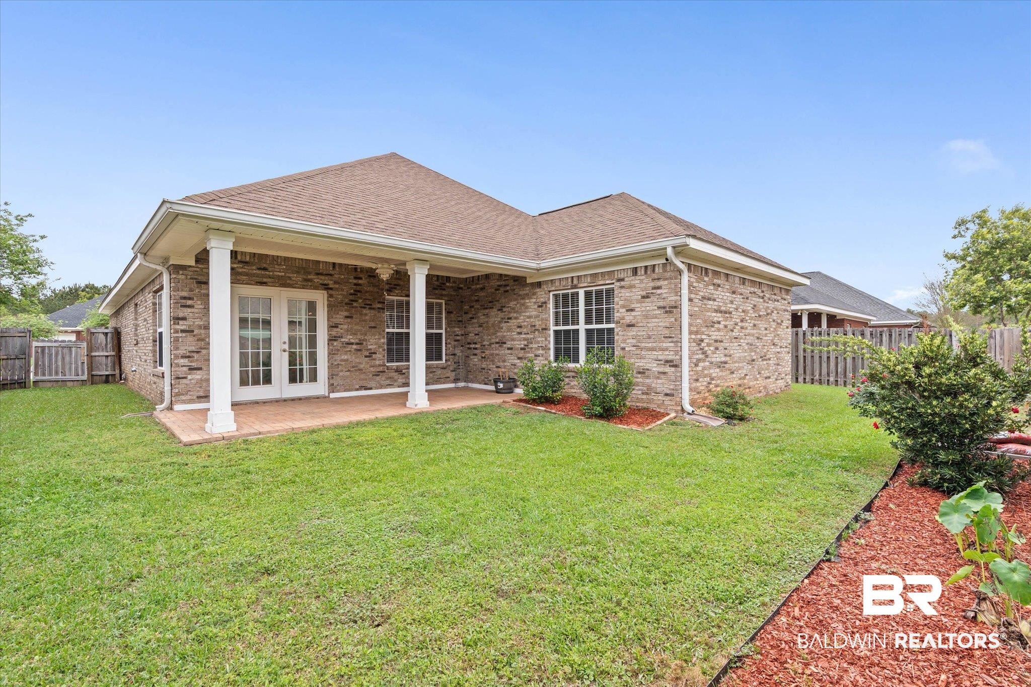 1003 Weatherby Street South Saraland, AL 36571 - Photo 27 of 31 Back of house with a fenced backyard, brick siding, a patio, roof with shingles, and french doors