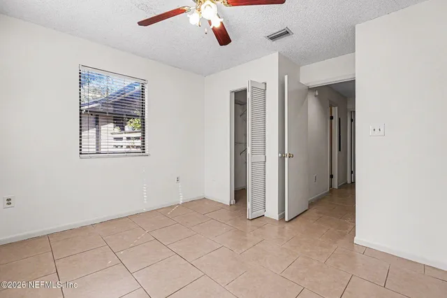 a view of an empty room with window and cabinet