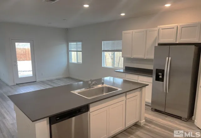 a kitchen with stainless steel appliances granite countertop a sink a refrigerator and a granite counter tops