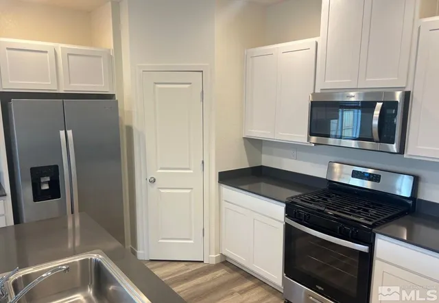 a kitchen with stainless steel appliances granite countertop a stove microwave and refrigerator