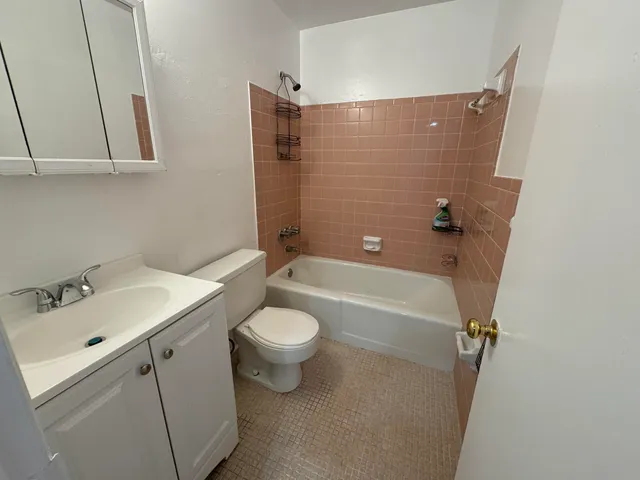 a bathroom with a sink mirror vanity and toilet