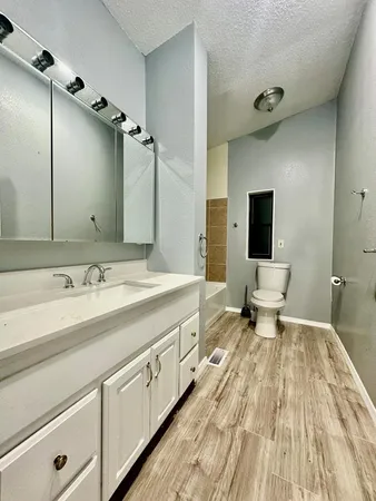 a spacious bathroom with a double vanity sink toilet and mirror