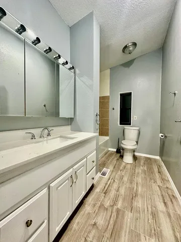 a spacious bathroom with a double vanity sink toilet and mirror