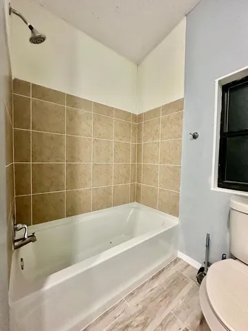 a bathroom with a bathtub and toilet