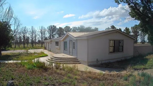 a view of a house with backyard and trees