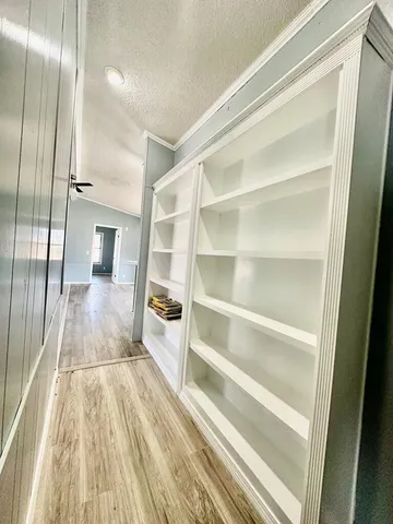 a view of a room with wooden floor and entryway