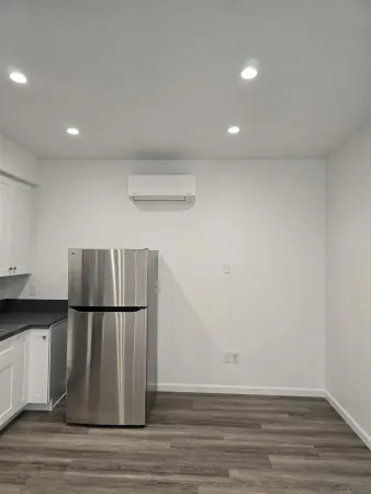 a view of a refrigerator in kitchen and wooden floor