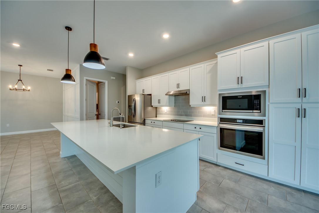 11674 Russet Trail Fort Myers, FL 33913 - Photo 11 of 47 a large kitchen with stainless steel appliances granite countertop a sink a stove and a refrigerator