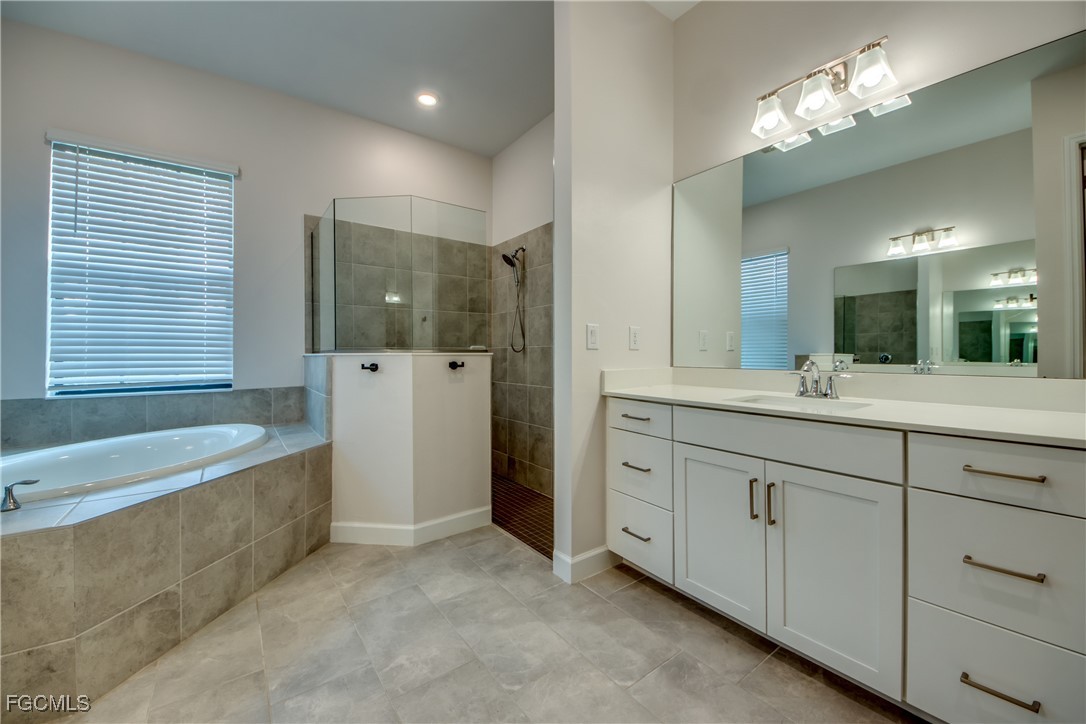 11674 Russet Trail Fort Myers, FL 33913 - Photo 14 of 47 a spacious bathroom with a double vanity sink a large mirror and a bathtub