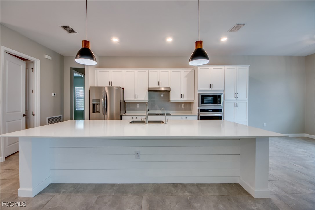 11674 Russet Trail Fort Myers, FL 33913 - Photo 9 of 47 a room with kitchen island a counter and cabinets