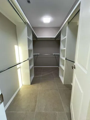 a view of walk in closet with empty racks