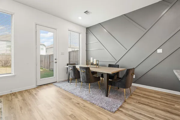 a dining room with furniture and wooden floor