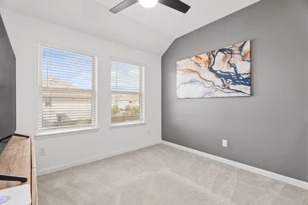 an empty room with a window and a fan