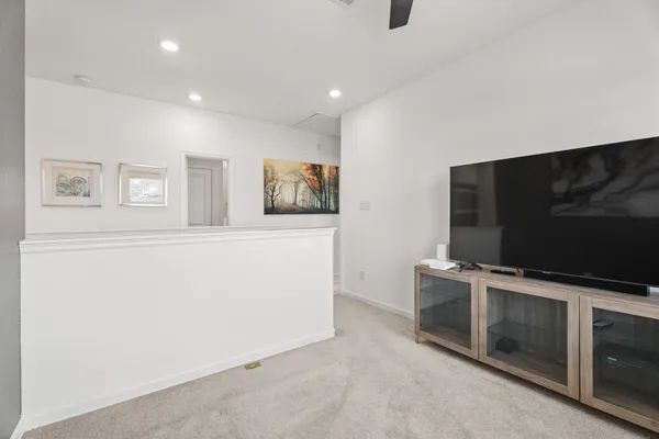 a living room with stainless steel appliances furniture and a flat screen tv