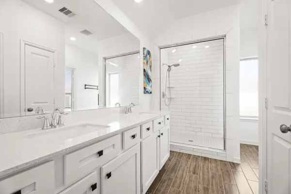 a bathroom with a double vanity sink a mirror and a shower
