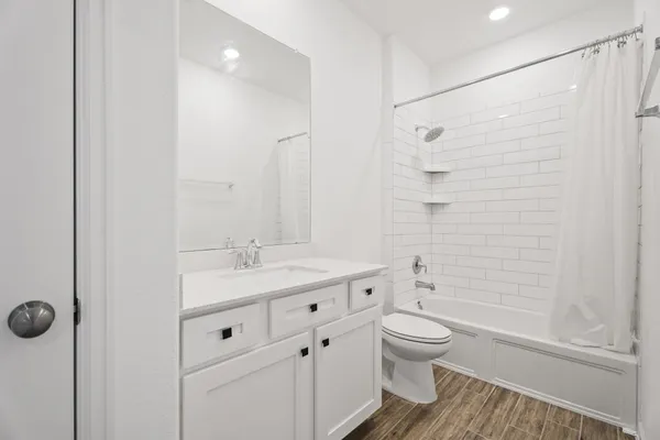 a bathroom with a granite countertop sink a toilet and shower