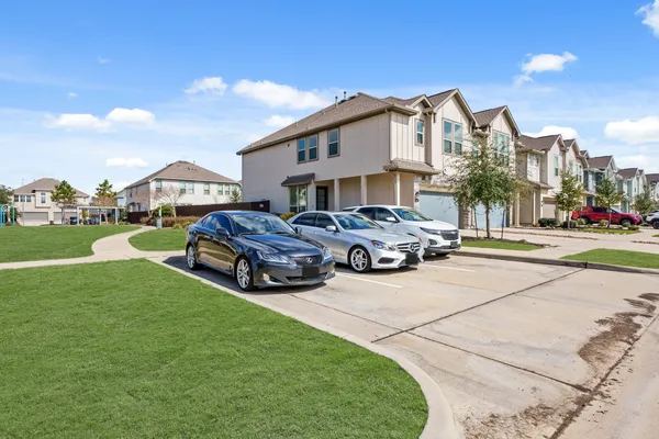 a view of a big house with a big yard and large trees