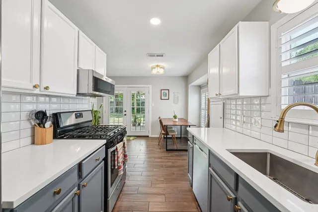 a kitchen with a sink stove and cabinets