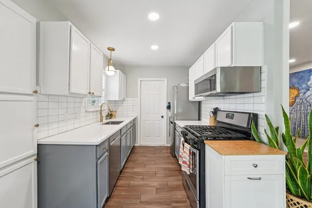 a kitchen with stainless steel appliances a stove sink microwave and cabinets