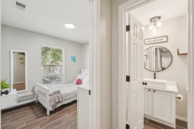 a bedroom with a bed a mirror and a window