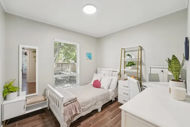 a bedroom with a bed and wooden floor