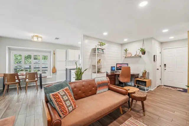 a living room with furniture and a wooden floor