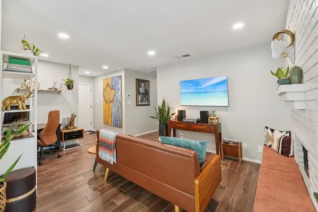 a living room with furniture a wooden floor and a rug