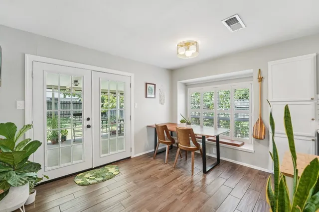 a dining room with furniture garden view and wooden floor