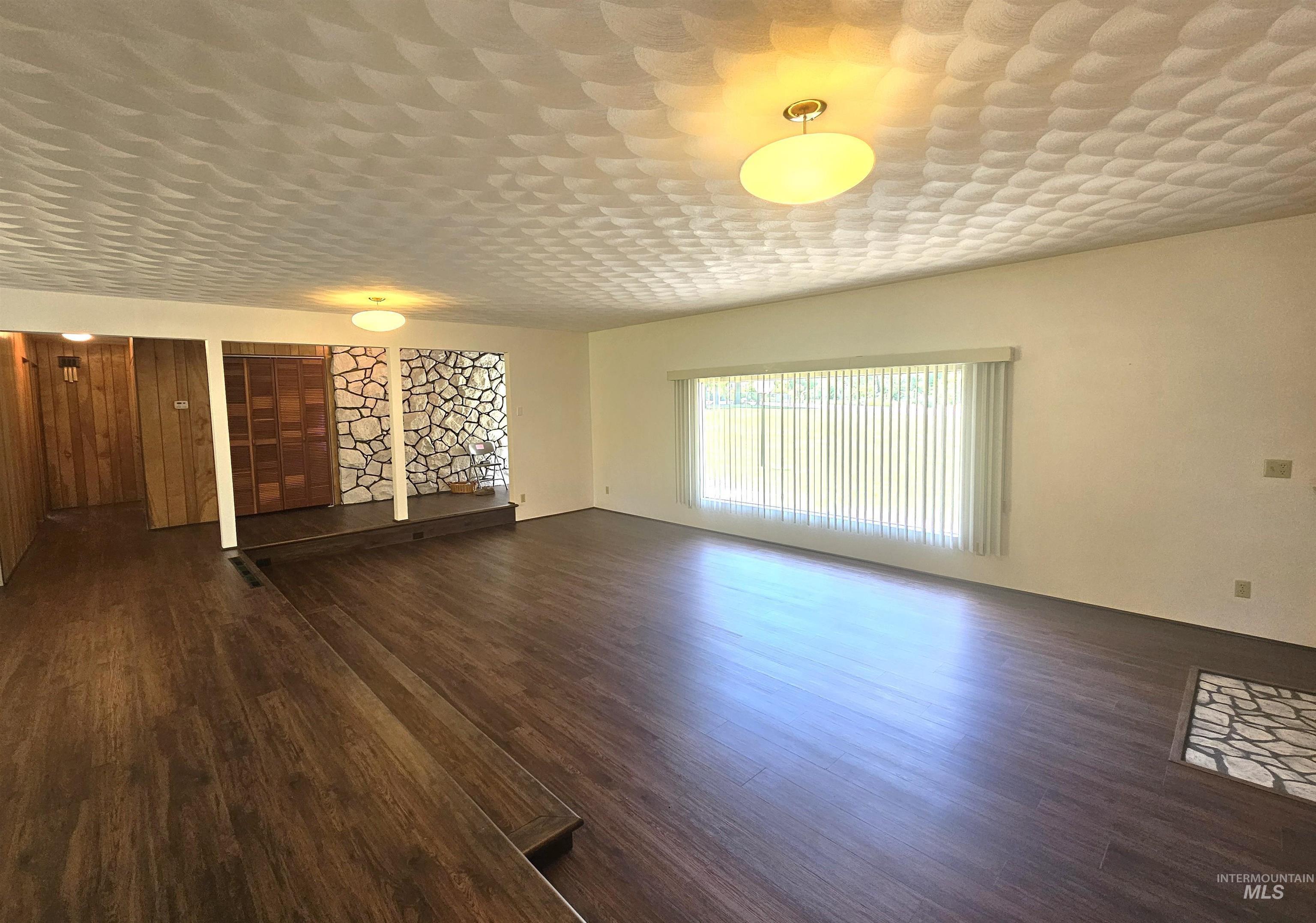 29865 Mission Creek Road Culdesac, ID 83524 - Photo 5 of 43 Spacious living area featuring dark wood-finish flooring and a stone accent wall