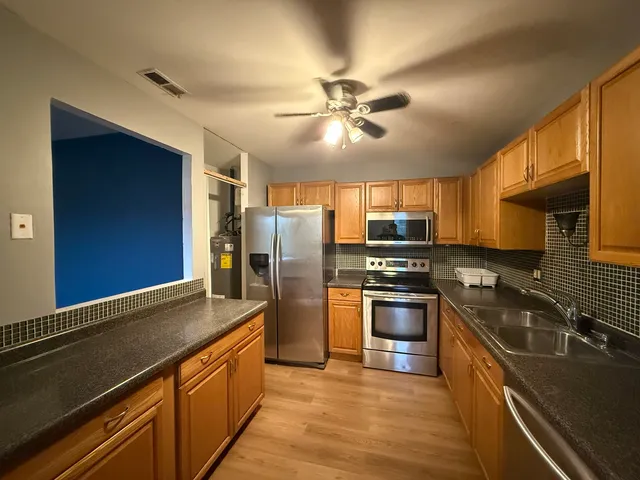 a kitchen with stainless steel appliances granite countertop a stove refrigerator sink and dishwasher