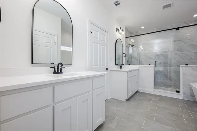 a bathroom with a double vanity sink mirror and shower