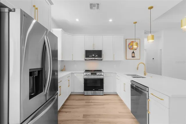 a kitchen with stainless steel appliances granite countertop a stove sink and refrigerator
