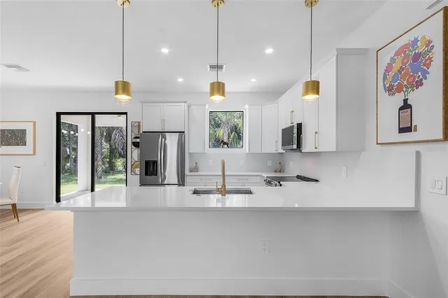 a view of a kitchen with a sink and mirror