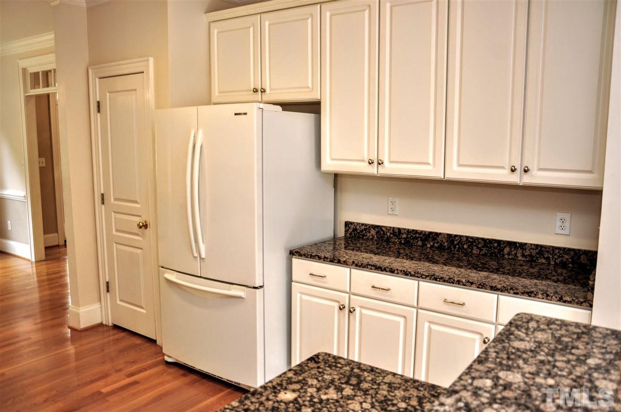 6902 Ray Road Raleigh, NC 27613 - Photo 4 of 23 a kitchen with granite countertop white cabinets and white appliances