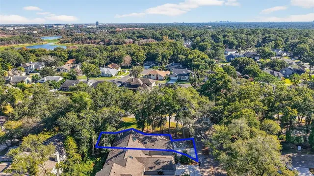 an aerial view of residential houses with outdoor space and trees