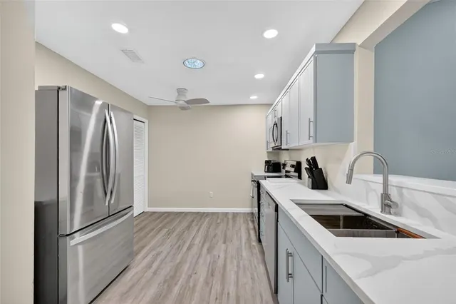 a kitchen with a sink a refrigerator and cabinets