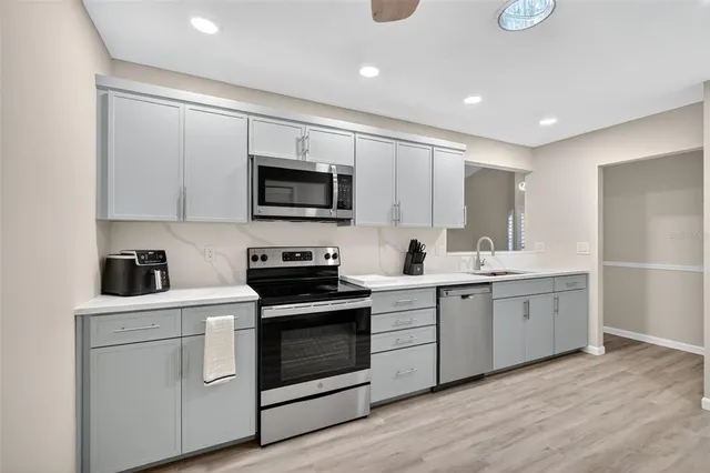 a kitchen with white cabinets stainless steel appliances and sink
