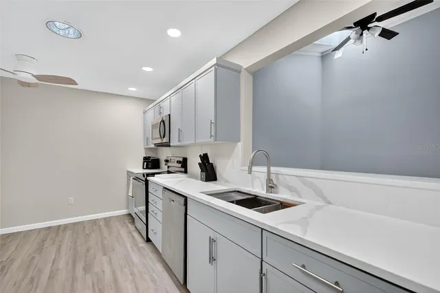 a kitchen with a sink a stove and cabinets
