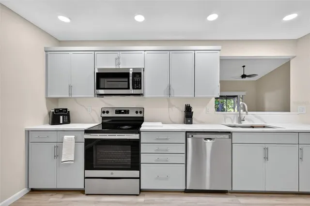 a kitchen with white cabinets stainless steel appliances and sink