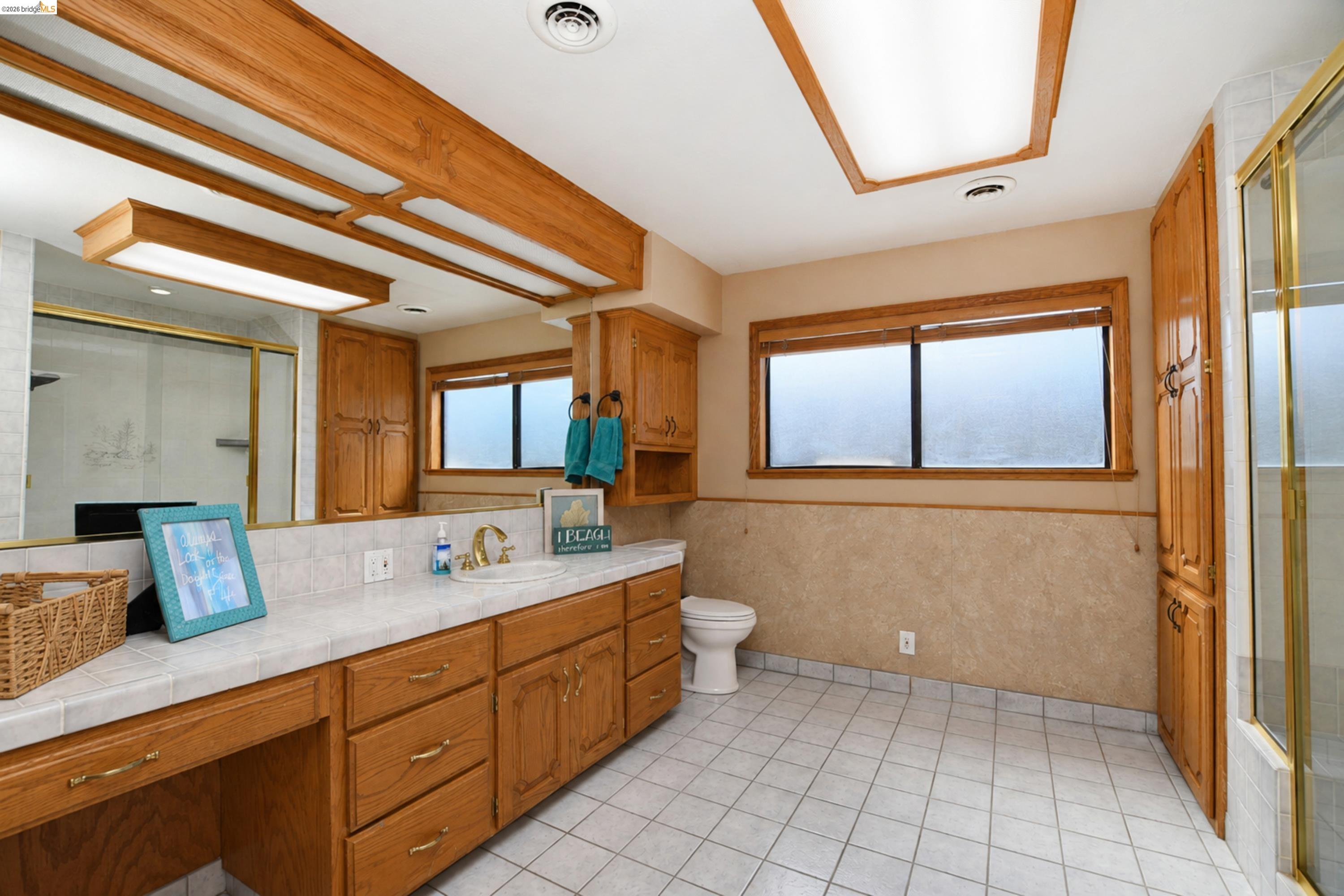 340 West Bolton Road Oakley, CA 94561 - Photo 34 of 87 Spacious bathroom featuring an extended vanity with dual sinks, ample wood cabinetry, a built-in shower, and a large mirror