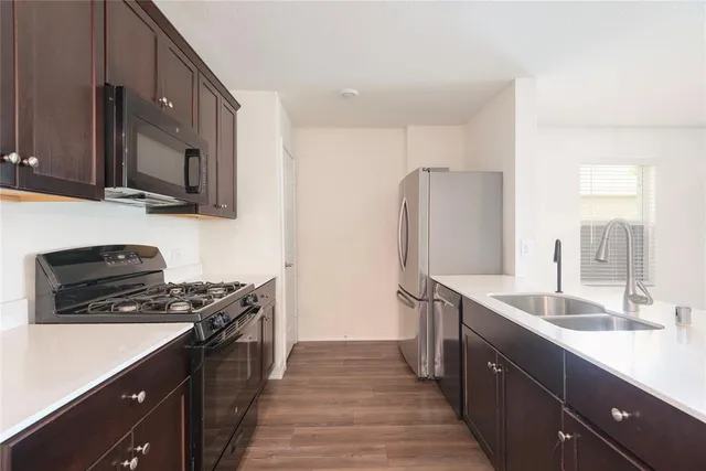 a kitchen with stainless steel appliances a sink stove and refrigerator