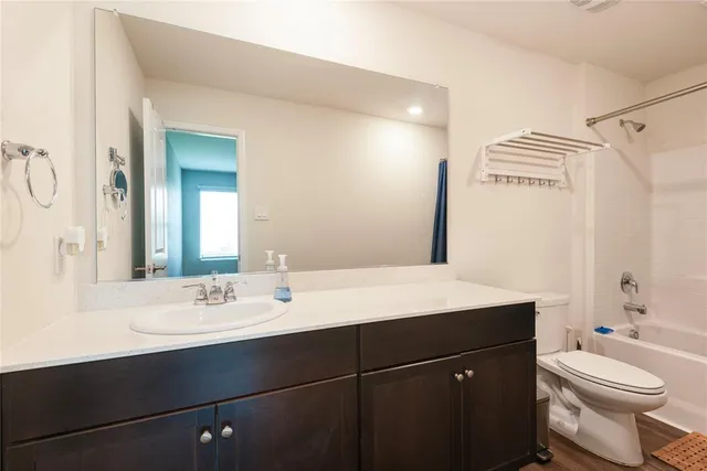 a bathroom with a sink vanity mirror and toilet