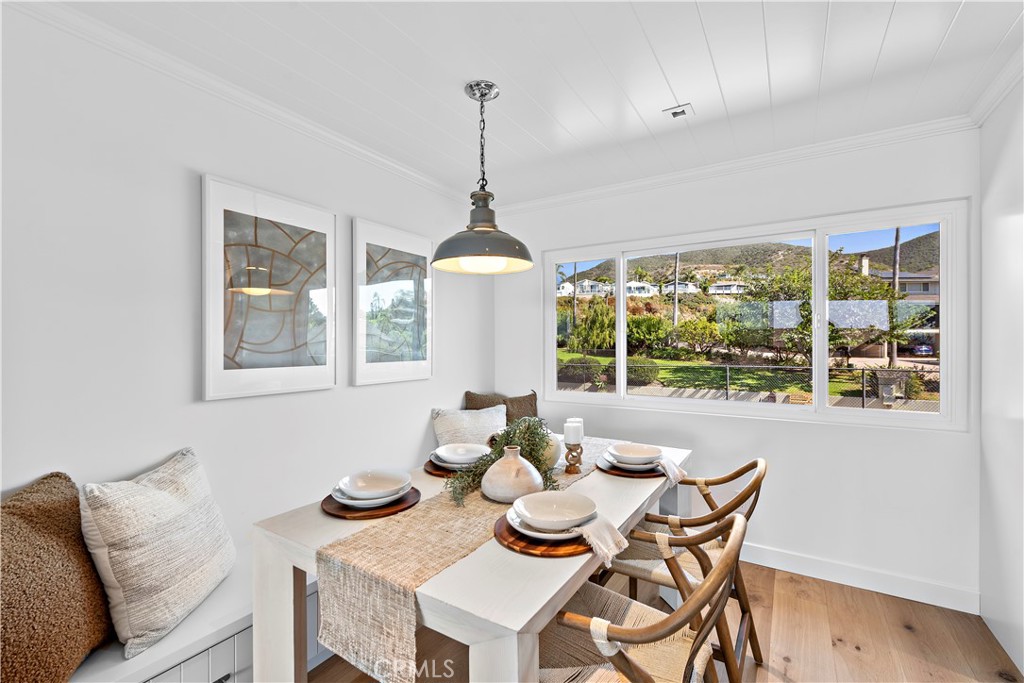 25 Blue Lagoon Laguna Beach, CA 92651 - Photo 16 of 53 a dining room with furniture a chandelier and wooden floor