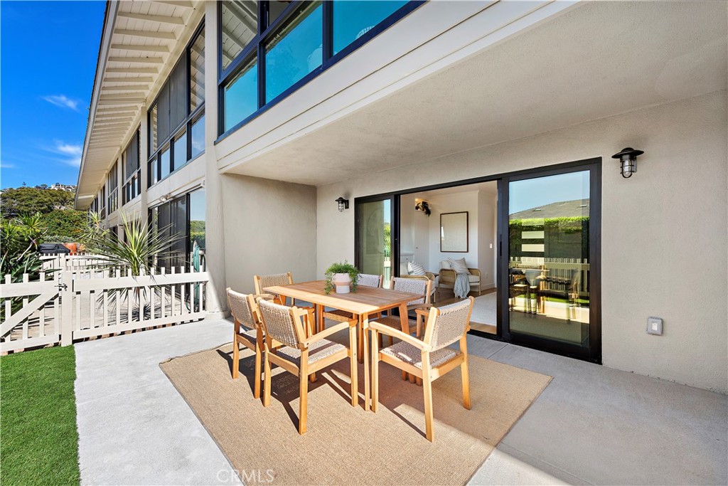 25 Blue Lagoon Laguna Beach, CA 92651 - Photo 23 of 53 a view of a patio with dining table and chairs with wooden floor and fence